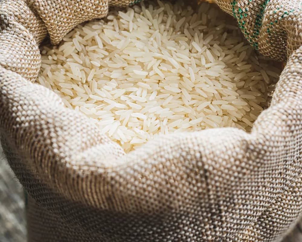 Bag of uncooked rice on a wooden surface