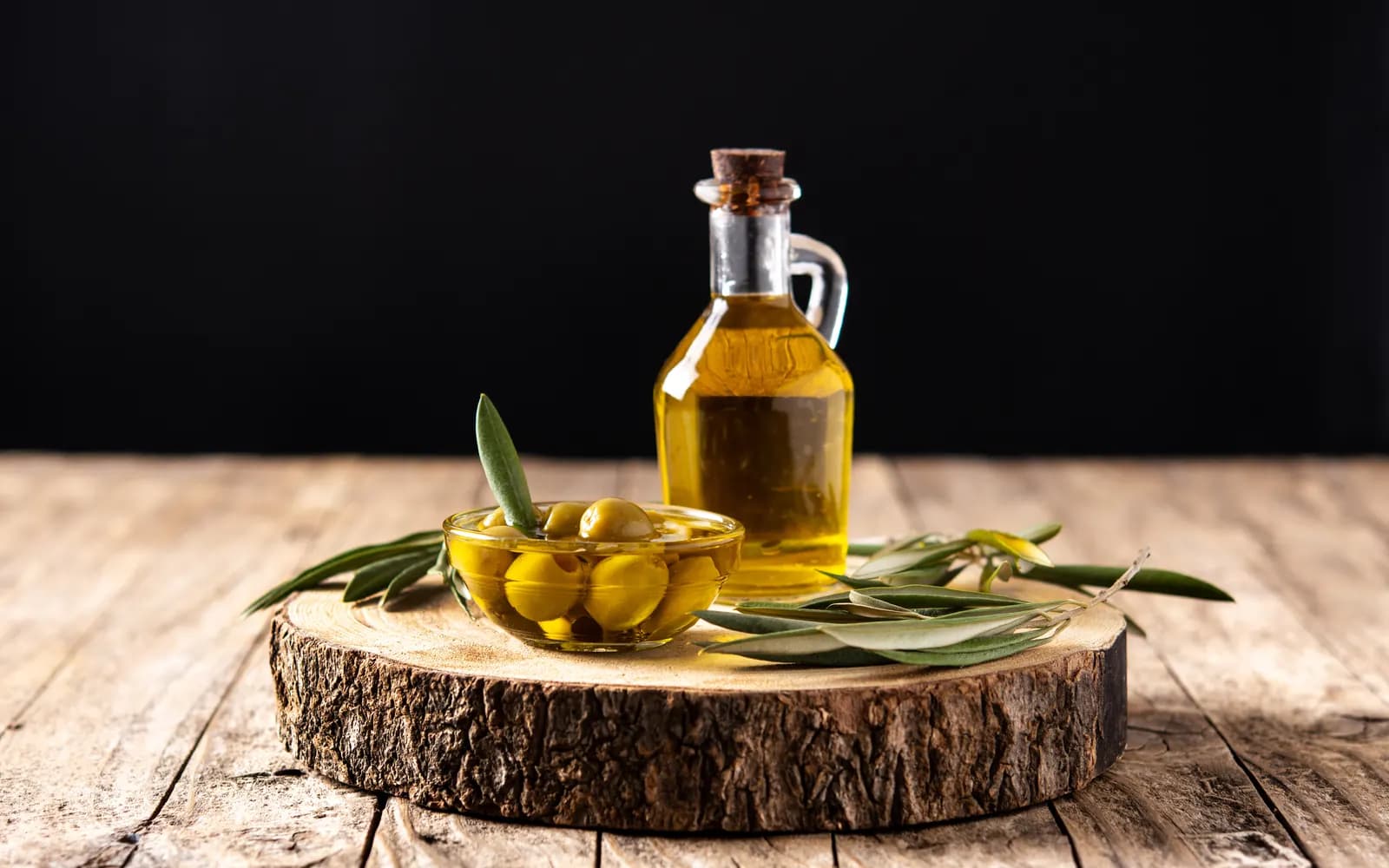 Olive oil and olives on a wooden table