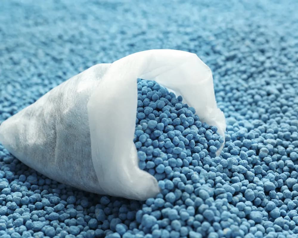 Blue nitrogen fertiliser granules overflowing from a bag